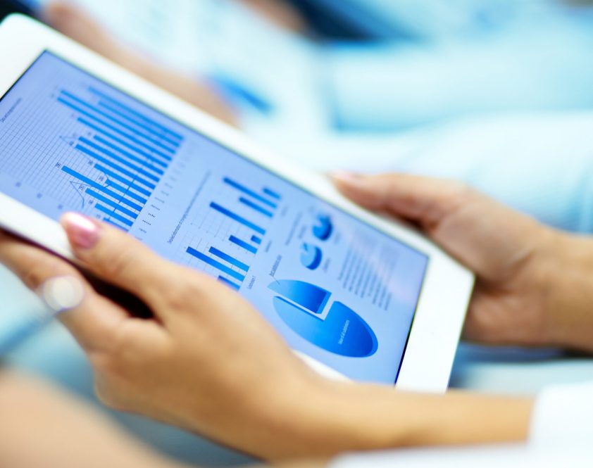 Businesswoman hands with touchpad while learning situation on the market