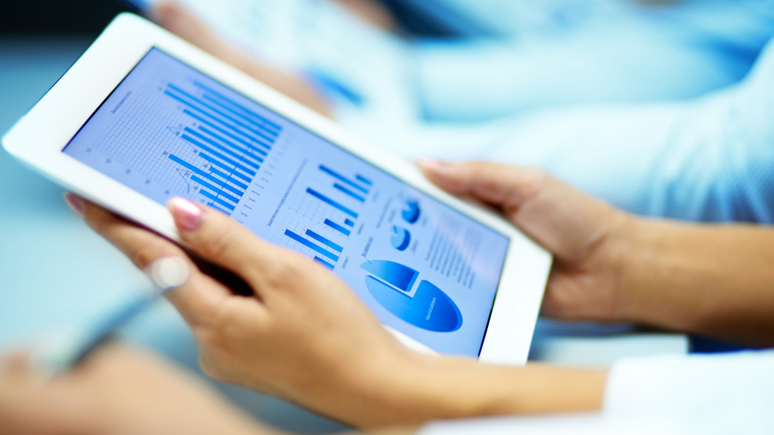 Businesswoman hands with touchpad while learning situation on the market